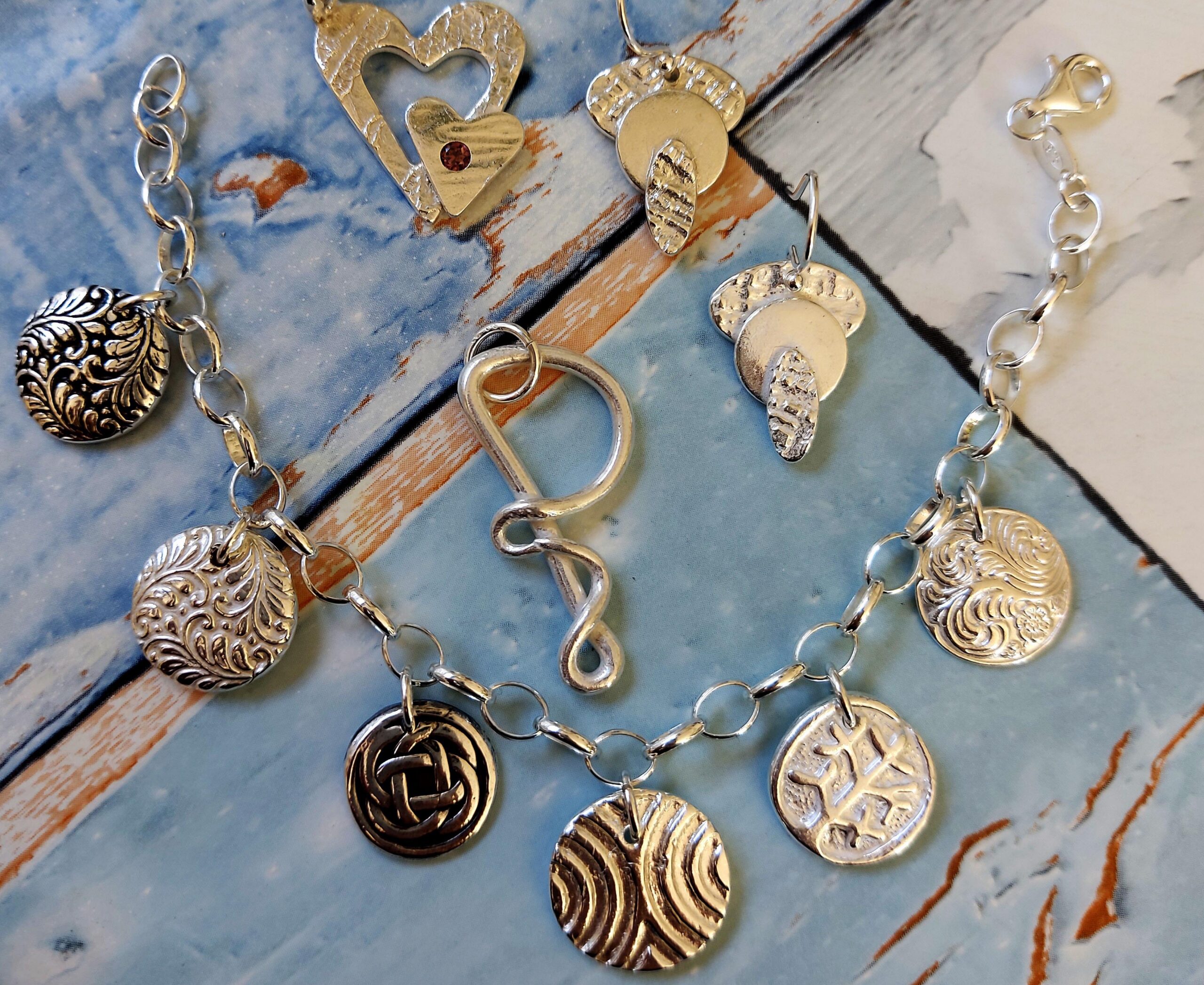 Penny A silver clay pendants on blue